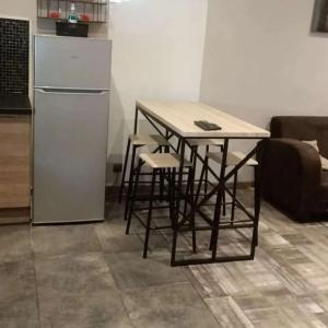 einen Tisch mit Stühlen und einen Kühlschrank in der Küche in der Unterkunft Loft 100 M2 Marseille 4 ème avec jacuzzi in Marseille