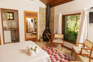 a bedroom with a bed and a fireplace at Pousada das Bromélias in Ipiabas