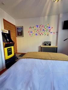 1 dormitorio con cama y videojuego en Ambiance 80 Stranger Things, en Lunéville