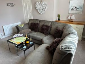a living room with a couch and a table at 5 Beechcroft Cottage - Seahouses Northumberland in Seahouses