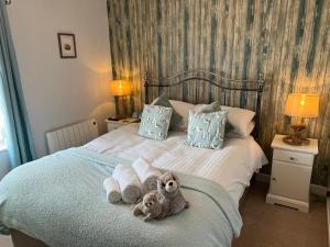 a teddy bear sitting on a bed with towels at 5 Beechcroft Cottage - Seahouses Northumberland in Seahouses