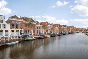 un río con barcos en una ciudad con edificios en Appartement Bierkade en Alkmaar