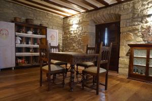 a table and chairs in a room with a stone wall at Arganzón Plaza in La Puebla de Arganzón