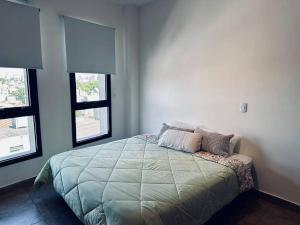 a bedroom with a large bed with two windows at Depto en Buenos Aires, Ciudadela. in Ciudadela