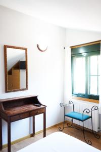 a mirror and a piano in a room with a chair at Casa Videira - Hotel rural cerca del mar in Bueu
