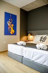 a bedroom with a bed with a guitar on the wall at Ambient Living Lofts in Preveza