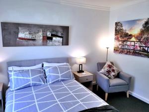 a bedroom with a blue bed and a chair at No.8 - One bedroom retreat in central Bendigo in Bendigo