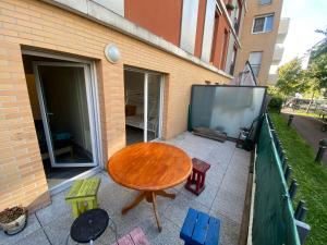 a patio with a wooden table and chairs on a balcony at appartement proche de paris in Saint-Denis