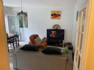 a living room with a couch and a flat screen tv at appartement proche de paris in Saint-Denis