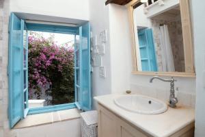 a bathroom with a sink and a window at Historical Stone Manor-Upper floor in Hydra