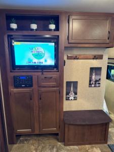 a living room with a tv and a entertainment center at The paradise in Lehigh Acres