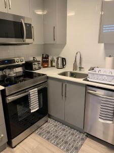 a kitchen with a stove top oven next to a sink at Niagara Getaway across Fallsview in Niagara Falls