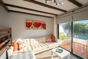 salon z kanapą i dużym oknem w obiekcie Casa Vega - Chalet adosado con piscina w mieście Breña Baja
