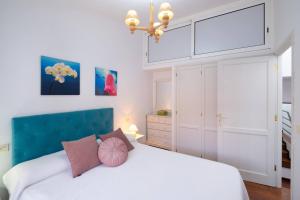 sypialnia z białym łóżkiem z niebieskim zagłówkiem w obiekcie Casa Vega - Chalet adosado con piscina w mieście Breña Baja