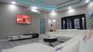 a living room with white furniture and a painting on the wall at Golden Pear Villa-CR in Confer