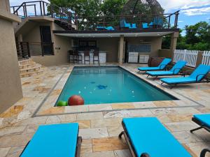 a pool with blue chairs and a ball in it at Golden Pear Villa-CR in Confer