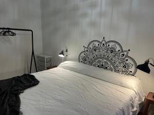 a bedroom with a white bed with a black headboard at Casa Las Pozas in Olite +16 photos