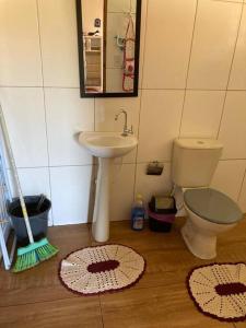 een badkamer met een wastafel, een toilet en een spiegel bij Chalé Nova Aurora in São Thomé das Letras
