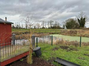 einen Zaun auf einem Feld mit einem Tennisplatz in der Unterkunft Red Sheds Cabin in Portarlington