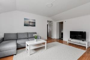 a living room with a couch and a tv at Komplett lägenhet med sjöutsikt in Malmön