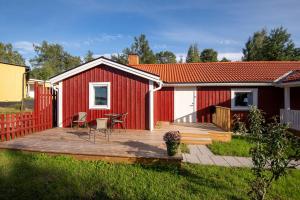 a red shed with a deck in the yard at Komplett lägenhet med sjöutsikt in Malmön