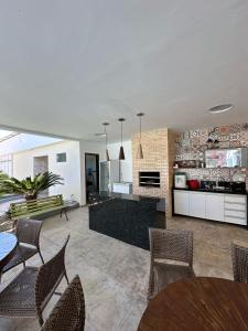 a kitchen and living room with tables and chairs at Pousada Olho D'água in São Luís