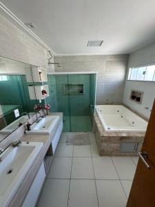 a bathroom with two sinks and a tub and a shower at Pousada Olho D'água in São Luís