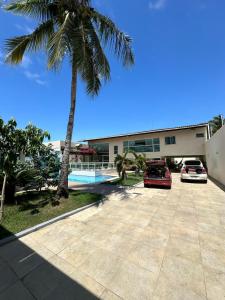 two cars parked in front of a building with a palm tree at Pousada Olho D'água in São Luís +25 photos