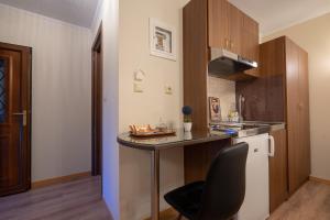 a small kitchen with a counter and a chair at Voulas Traditional House Meteora 1 in Kalabaka
