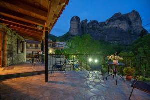 a patio with chairs and a table with a mountain at Voulas Traditional House Meteora 1 in Kalabaka