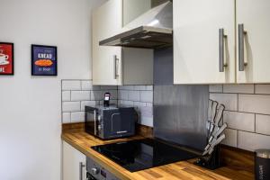 a kitchen with a counter top with a microwave at Home in West Yorkshire, Close to Leeds City Center, Sleeps 3! in Batley