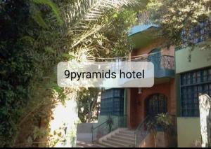 een bord waarop staat piramides hotel voor een gebouw bij 9pyramids hotel in Caïro