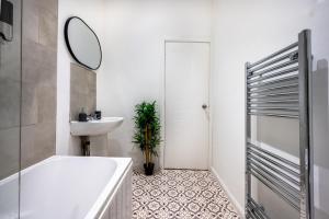 a bathroom with a tub and a sink and a mirror at Home in West Yorkshire, Close to Leeds City Center, Sleeps 3! in Batley +18 photos
