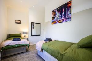 バットレイにあるHome in West Yorkshire, Close to Leeds City Center, Sleeps 3!のベッドルーム1室(ベッド2台、鏡付)