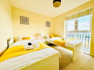 布里斯托Modern 2-Bedroom Apartment的一间有两张床和一扇大窗户的卧室