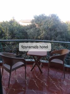een bord met de tekst 'spymants hotel' zittend op een tafel en stoelen bij 9pyramids hotel in Caïro