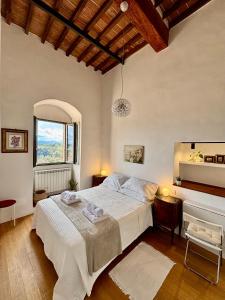 a bedroom with a large white bed and a window at La Torre di Canonica in Colle Val D'Elsa