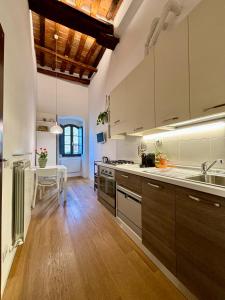 cocina grande con suelo de madera y mesa en La Torre di Canonica, en Colle Val D'Elsa
