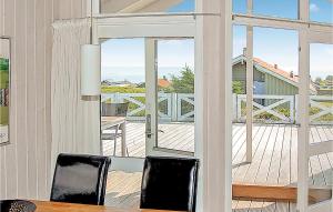 HejlsにあるStunning Home In Sjlund With House Sea Viewのダイニングルーム(デッキに面したガラスのスライドドア付)