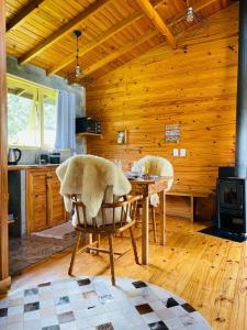 uma cozinha com uma mesa e cadeiras num camarote em Cabana Refúgio - Pousada Colina dos Ventos em Urubici