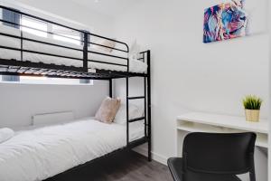een slaapkamer met een bureau en een stapelbed bij Dazzling & Modern 4bd - Nr Etihad - Parking -EV in Manchester