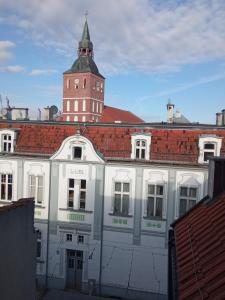 a white building with a clock tower on top of it at Apartament Warmiński - Old Town in Biskupiec