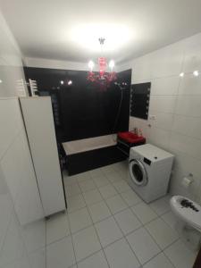a bathroom with a toilet and a tub and a sink at Apartament Old Town in Biskupiec +4 photos