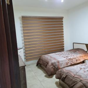 a bedroom with two beds and a large window at 2 bedrooms apartment no 18 in Amman