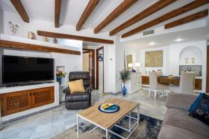 een woonkamer met een grote televisie en een tafel bij Aldea del Mar Buganvilla Apartament in Torrevieja