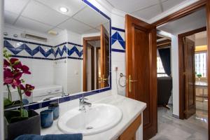 een badkamer met een wastafel en een spiegel bij Aldea del Mar Buganvilla Apartament in Torrevieja +24 foto's