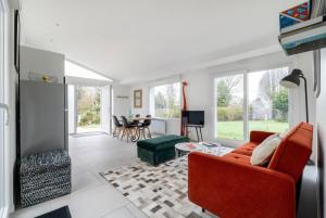 ein Wohnzimmer mit einem roten Sofa und einem Kamin in der Unterkunft Villa entourée de verdure avec parking privé in Halluin