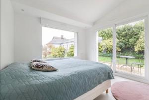 1 dormitorio con cama y ventana grande en Villa entourée de verdure avec parking privé, en Halluin