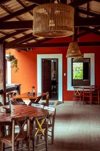 a dining room with red walls and wooden tables and chairs at EcoPousada Pico do Jabre in Matureia