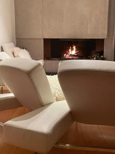 a white chair in a living room with a fireplace at Casa vistas al mar con piscina y barbacoa in Benicàssim